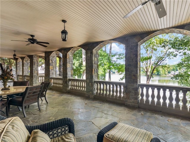 view of patio / terrace featuring outdoor dining area, ceiling fan, and a water view