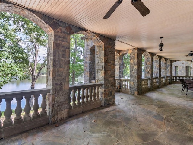 view of patio featuring covered porch, ceiling fan, and a water view