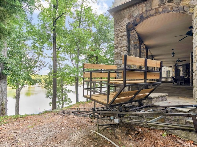 exterior space with a ceiling fan and a water view