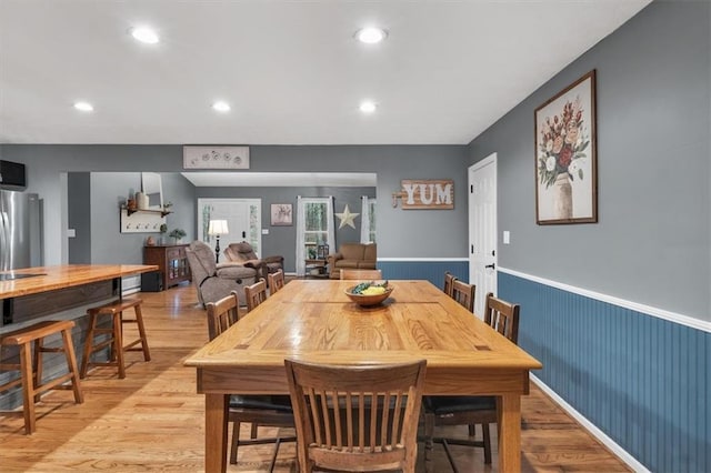 dining room with wainscoting, light wood-style flooring, and recessed lighting