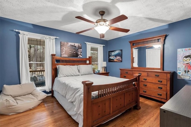 bedroom featuring a textured ceiling, ceiling fan, and wood finished floors