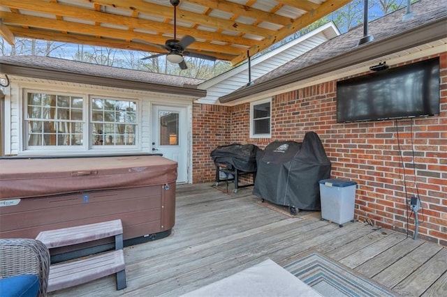 deck with area for grilling, a ceiling fan, and a hot tub