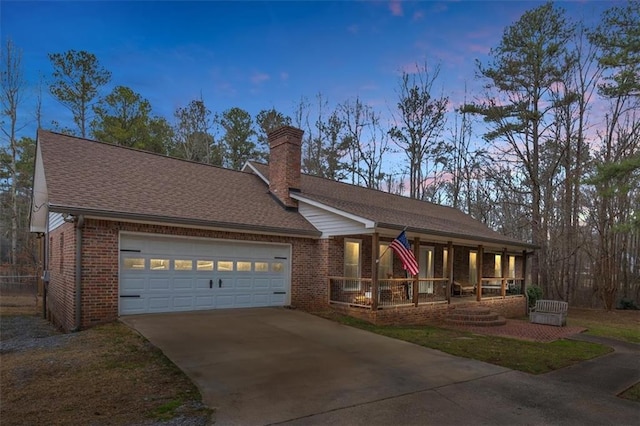 view of front of house featuring concrete driveway, a chimney, an attached garage, a porch, and brick siding