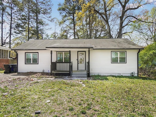 ranch-style home featuring covered porch and a front yard