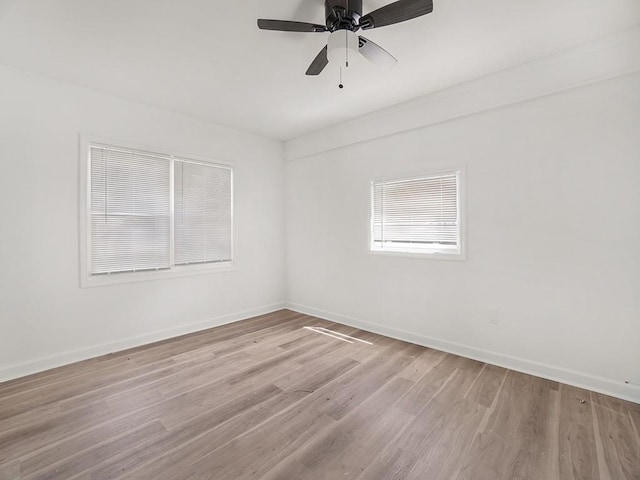 empty room with baseboards, a ceiling fan, and light wood-type flooring