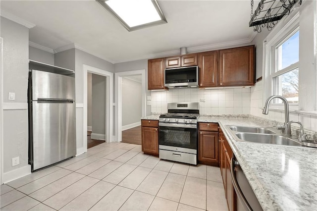 kitchen with sink, backsplash, ornamental molding, and appliances with stainless steel finishes