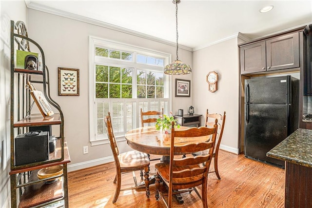 dining room with light wood-style floors, recessed lighting, crown molding, and baseboards