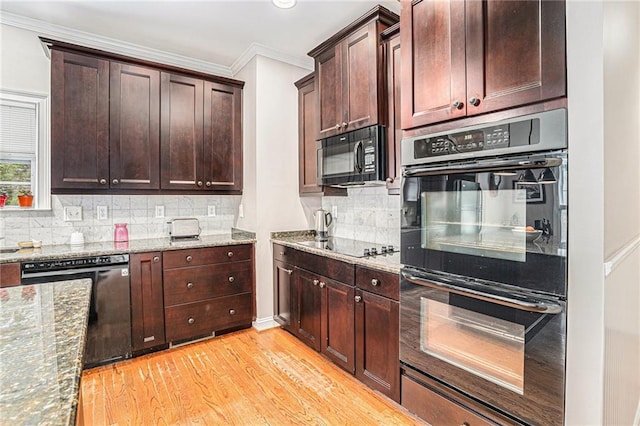 kitchen with light wood-style floors, black appliances, crown molding, and stone countertops