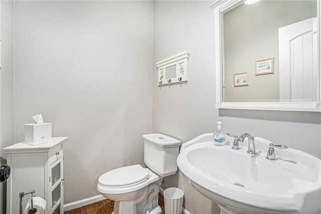 255 Heritage Creek Trl, Ball Ground, GA 30107 - half bath with a sink, toilet, wood finished floors, and baseboards