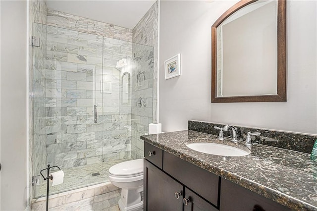 bathroom with toilet, a shower stall, and vanity