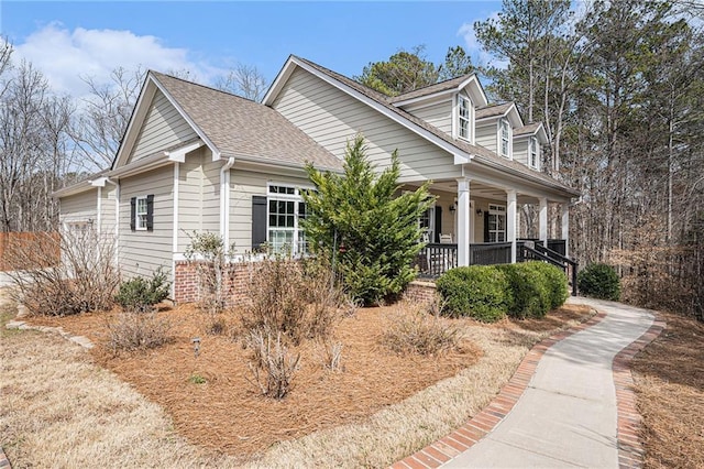 view of property exterior with covered porch and roof with shingles