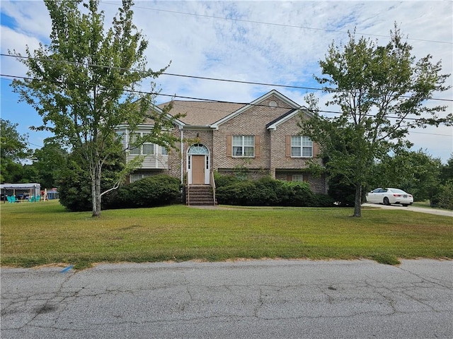 bi-level home featuring a front lawn and brick siding