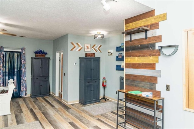 interior space featuring ceiling fan, hardwood / wood-style floors, and a textured ceiling