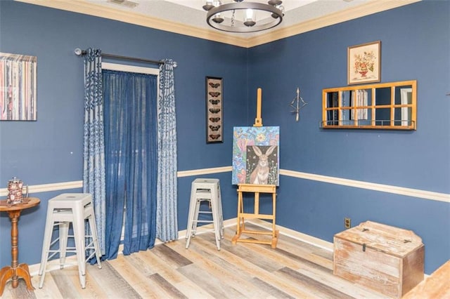 interior space with an inviting chandelier, wood-type flooring, and ornamental molding