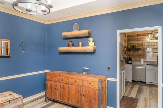 interior space with ornamental molding, sink, a chandelier, and light hardwood / wood-style flooring