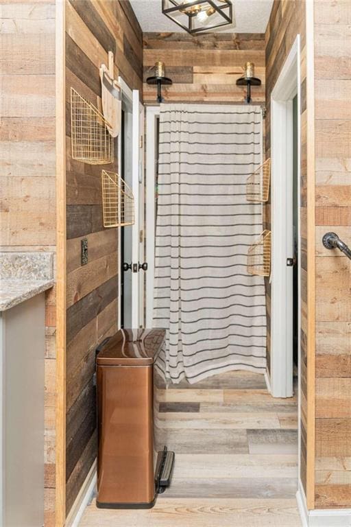 bathroom featuring hardwood / wood-style flooring and wood walls