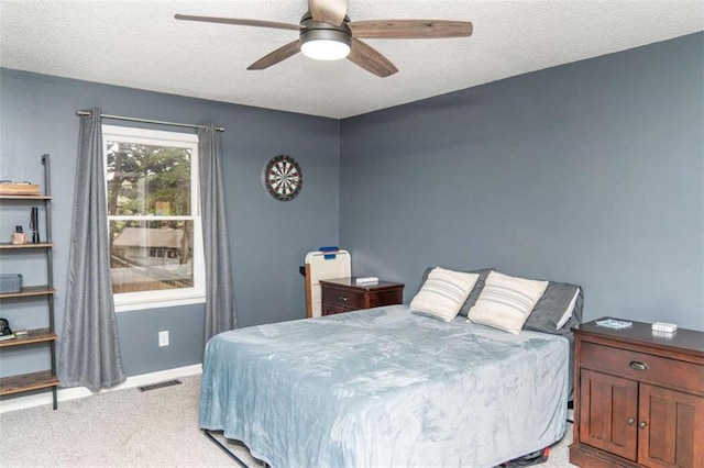 carpeted bedroom with ceiling fan and a textured ceiling