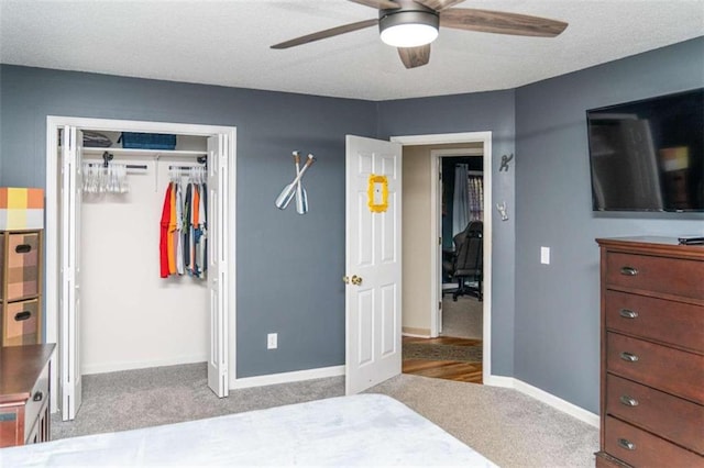 carpeted bedroom with ceiling fan and a closet