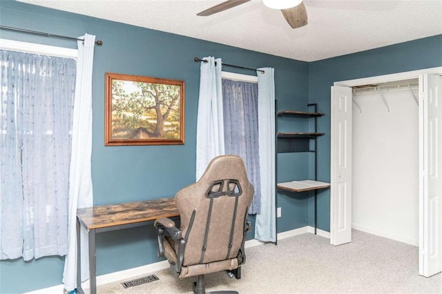 carpeted home office featuring ceiling fan