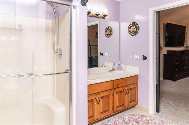 bathroom featuring vanity and a shower with door