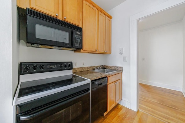 kitchen with sink, light hardwood / wood-style floors, light brown cabinets, and black appliances