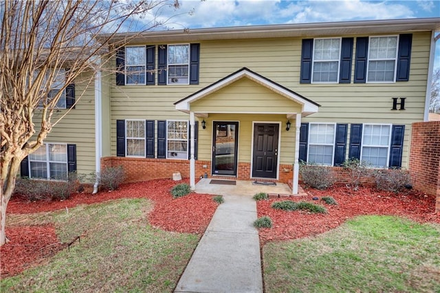 view of front of house featuring brick siding and a front yard