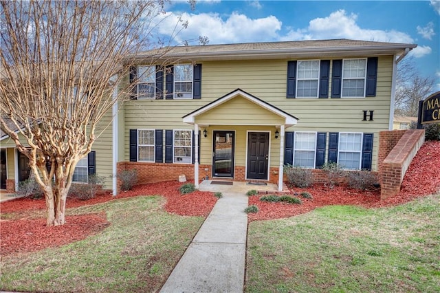 view of front of property featuring brick siding and a front yard