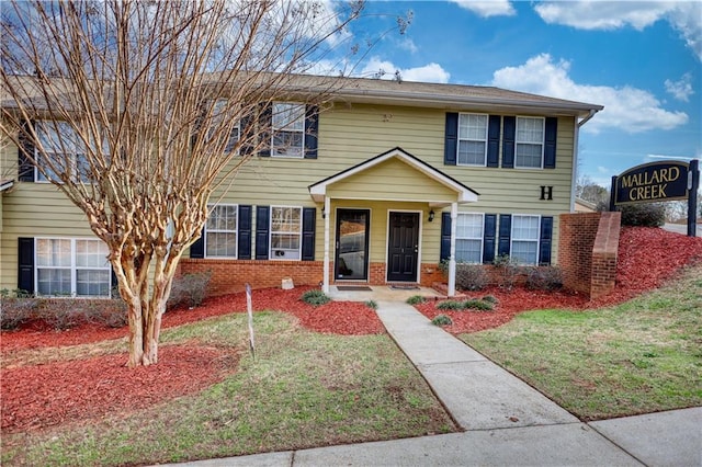 view of front of home with a front yard and brick siding