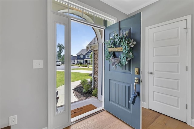 entryway with hardwood / wood-style flooring and ornamental molding