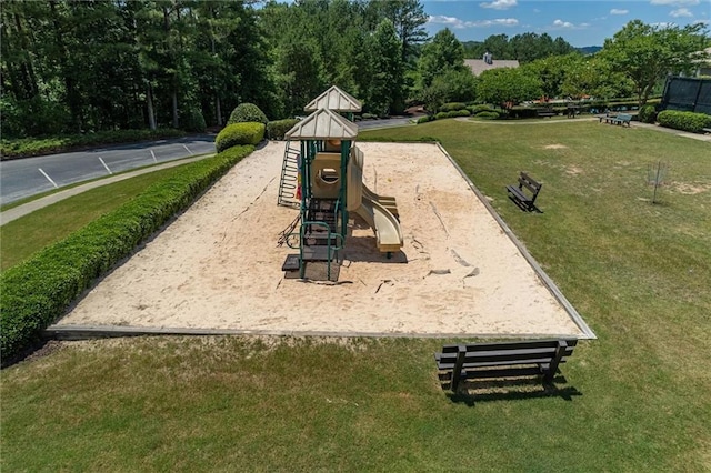 view of property's community featuring a yard and a playground