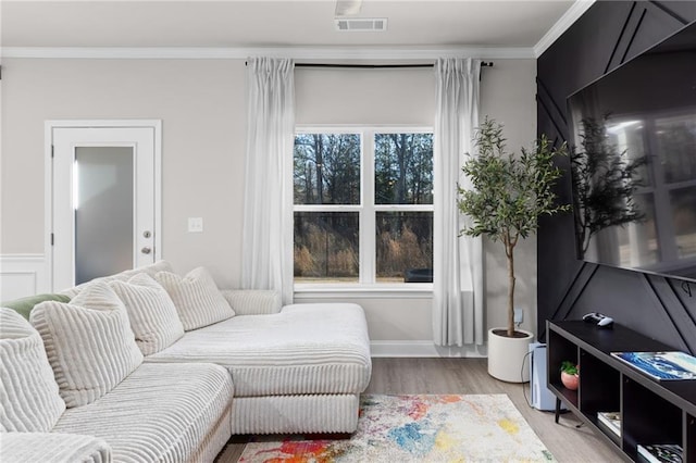 living room with crown molding and light hardwood / wood-style flooring