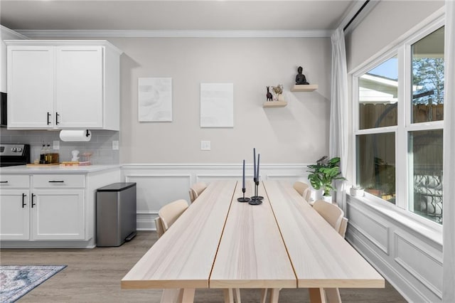 kitchen featuring backsplash, crown molding, light hardwood / wood-style floors, and white cabinets