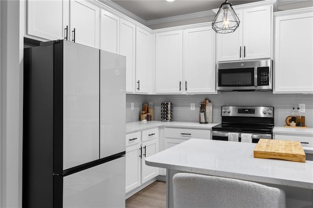 kitchen with stainless steel appliances, white cabinets, and decorative light fixtures