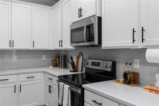 kitchen with white cabinetry, light stone counters, tasteful backsplash, and appliances with stainless steel finishes