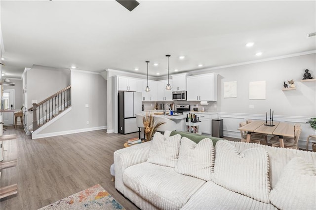 living room with ornamental molding and light hardwood / wood-style flooring