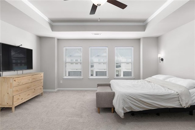 carpeted bedroom featuring crown molding, a raised ceiling, and multiple windows