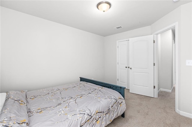 bedroom featuring light carpet and a closet