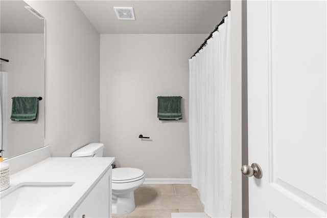 bathroom featuring vanity, tile patterned flooring, and toilet