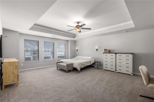 bedroom featuring light carpet, ornamental molding, a raised ceiling, and ceiling fan