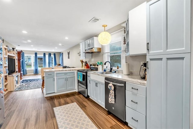 kitchen with stainless steel appliances, a wealth of natural light, a peninsula, and a sink