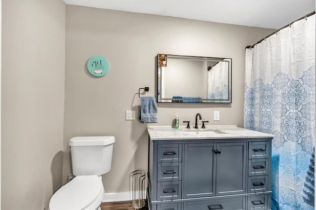 bathroom featuring vanity, baseboards, and toilet