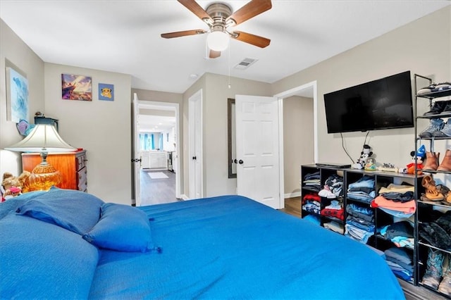 bedroom with visible vents, ceiling fan, baseboards, and wood finished floors