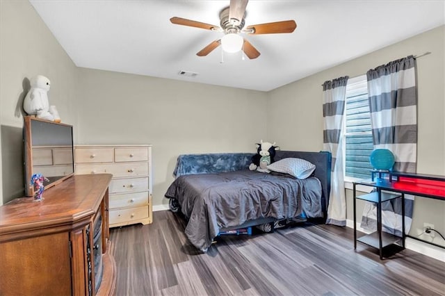 bedroom featuring dark wood-style flooring, visible vents, baseboards, and ceiling fan