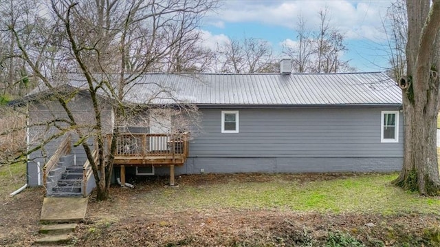 back of house featuring a wooden deck, metal roof, and stairs