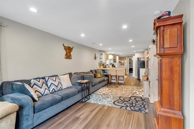 living room with light wood finished floors and recessed lighting
