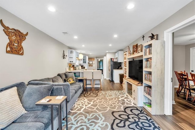living area featuring wood finished floors, visible vents, and recessed lighting