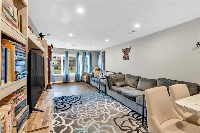 living area with wood finished floors, visible vents, and recessed lighting