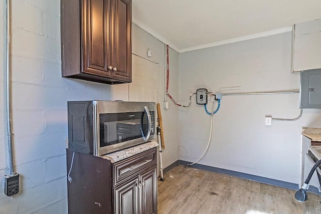 kitchen with dark brown cabinetry, ornamental molding, electric panel, and light hardwood / wood-style flooring