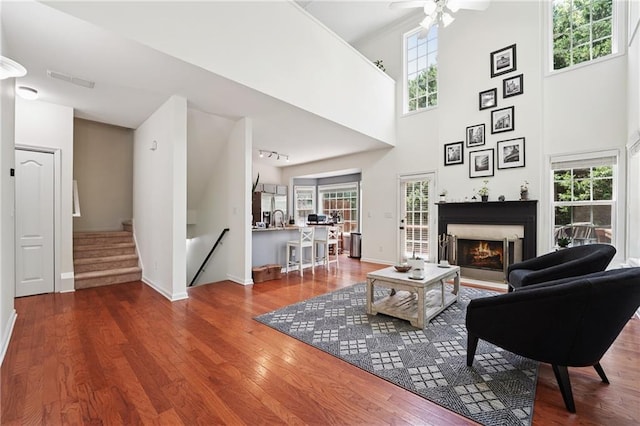 350 Eagle Tiff Dr, Sugar Hill, GA 30518 - living area featuring a lit fireplace, wood finished floors, healthy amount of natural light, and a high ceiling