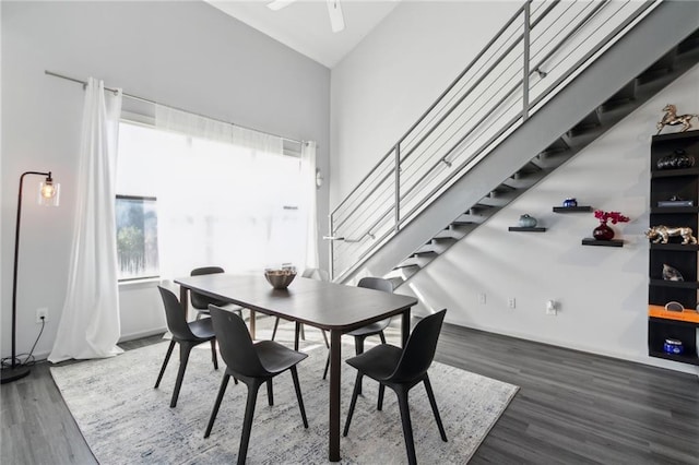 dining area featuring high vaulted ceiling and dark hardwood / wood-style flooring